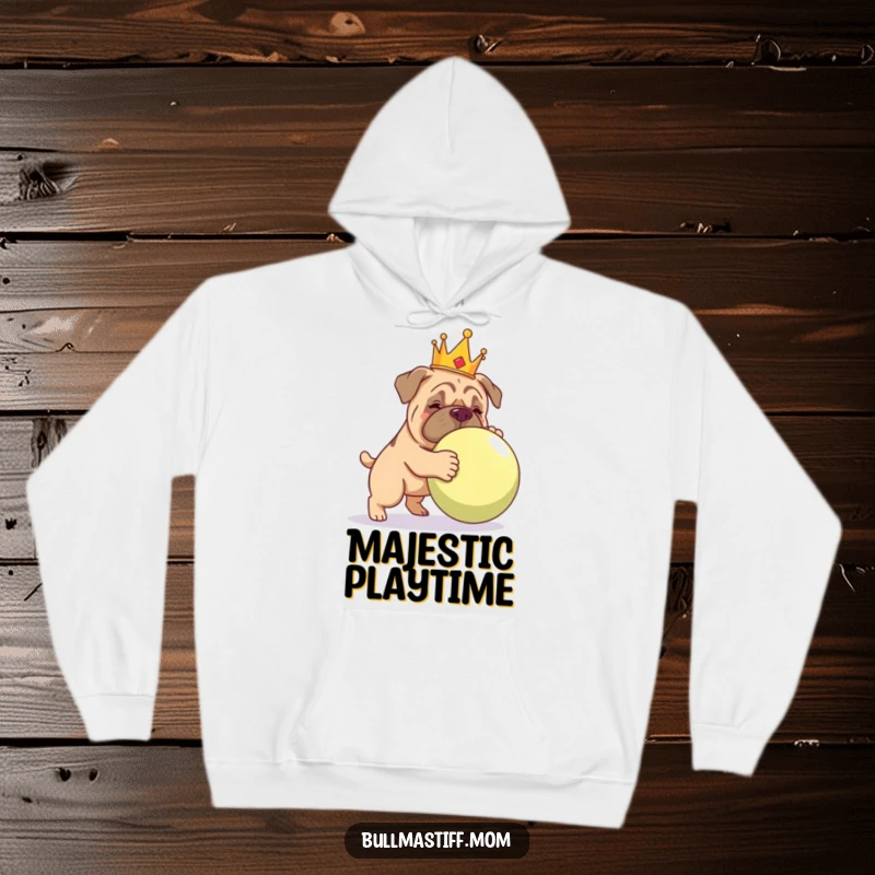 Funny Bullmastiff in a crown, playfully interacting with a massive ball, depicted on a warm hoodie.