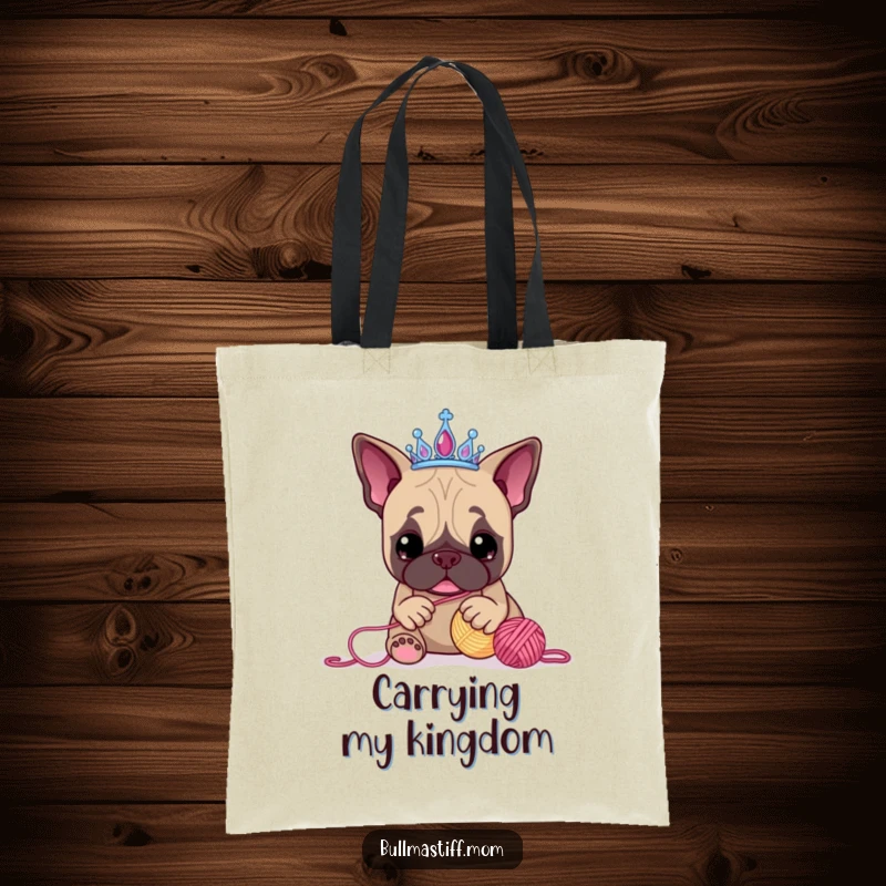 Funny Bullmastiff tote bag showcasing a tiara-wearing dog engaged in a comical battle with a ball of yarn, highlighting playful canine antics.